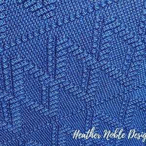 Puede incluir: Primer plano de una tela azul texturizada con un patrón repetitivo. La tela tiene una textura ligeramente en relieve, creando un efecto 3D.