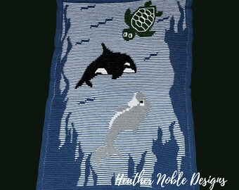 May include: A rectangular crochet blanket featuring a blue and white striped background with dark blue silhouettes of seaweed. The design includes a green sea turtle, a black orca, and a gray dolphin. The text Heather Noble Designs is at the bottom.