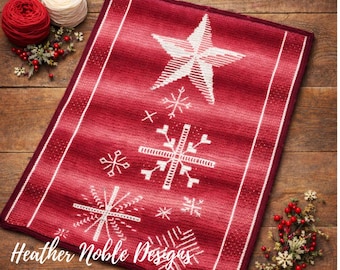 May include: A rectangular red knitted mat featuring a white star at the top and various white snowflake patterns below. The mat has a white border and the text Heather Noble Designs is printed in white script at the bottom left corner.