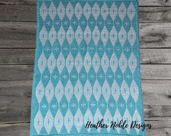 May include: A rectangular crochet blanket featuring a repeating geometric diamond pattern in teal and white. The design includes small star-like accents within the diamonds. The text Heather Noble Designs is printed in black in the bottom right corner.