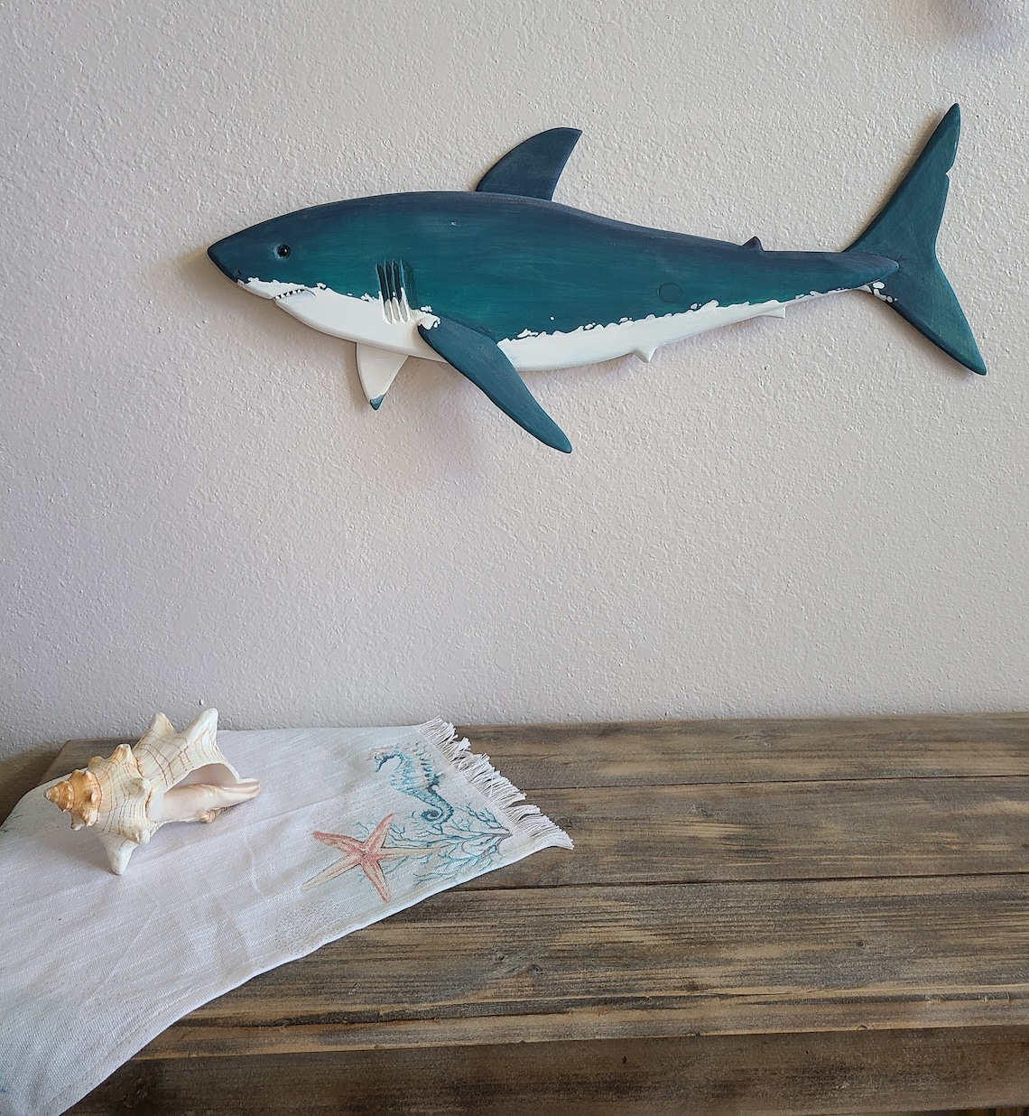 Hand-carved wooden shark art on a wall.