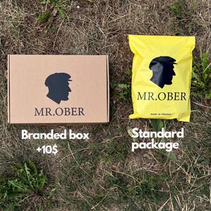May include: A rectangular brown cardboard box and a yellow plastic mailing bag. Both items feature a black silhouette logo of a person wearing a flat cap above the text MR.OBER. The yellow bag also includes the text made in Ukraine.