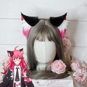 Può includere: Fascia per capelli con orecchie da gatto in finta pelliccia nera, bianca e rosa. Le orecchie sono esposte su una testa di manichino con capelli grigi, con fiori rosa sullo sfondo. Un accessorio cosplay.
