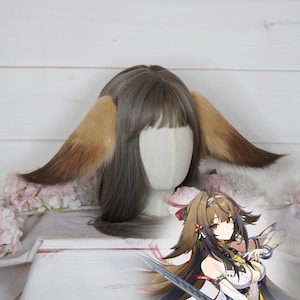 May include: A brown wig with straight hair, bangs, and two large, pointed, faux fur animal ears attached to the sides. The ears feature a gradient of light tan at the base transitioning to a dark brown at the tips. An anime character illustration is included.