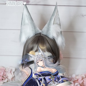 May include: A pair of white furry fox ears, worn as a headband. The ears are soft and fluffy, with a realistic appearance. The headband is made of a soft, comfortable material. The ears are a popular accessory for cosplay and anime fans.