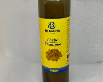 May include: A clear plastic bottle of "Bel Naturals Chebe Shampoo" with a yellow label. The label features the brand logo and a graphic of brown powder. The bottle contains a dark green liquid and is 236g.