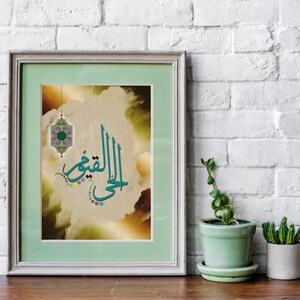 Pode incluir: Uma impressão emoldurada de caligrafia árabe com um design verde e azul. A caligrafia diz "Al-Rahim", que significa "O Mais Misericordioso". A impressão é colocada sobre um fundo de nuvens e um brilho dourado.