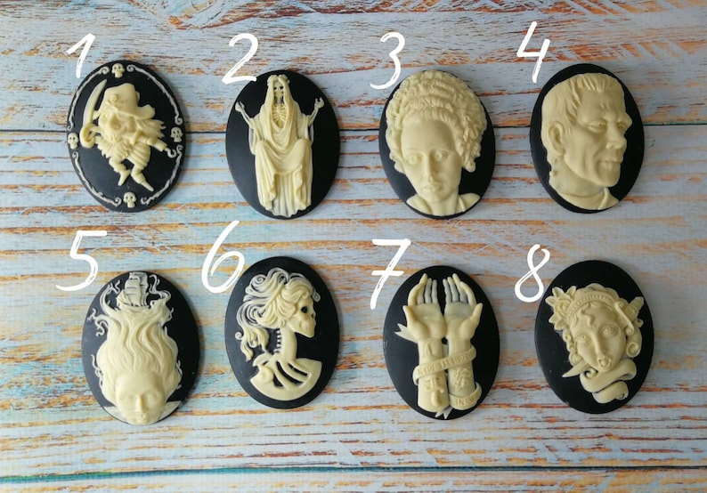 Op de afbeelding: Acht zwart-witte cameo-achtige hangers met verschillende Halloween-themaontwerpen. De hangers zijn genummerd van 1 tot en met 8.