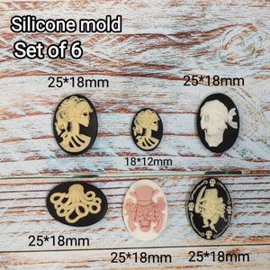 May include: Set of six silicone molds for making cameo-style resin jewelry. The molds are oval shaped and feature various designs, including a skull, an octopus, and a woman's profile. The molds are 25 mm x 18 mm and 18 mm x 12 mm in size.