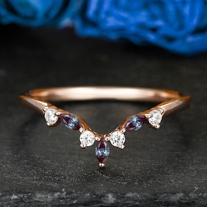 Könnte beinhalten: Ein zartes Roségold-Ehering mit geschwungenem Design. Der Ring ist mit kleinen runden Diamanten und markisenförmigen Alexandrit-Edelsteinen verziert.