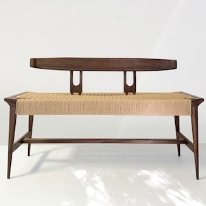 May include: A dark wood bench with a woven cane seat and a back rest. The bench has a simple, modern design.