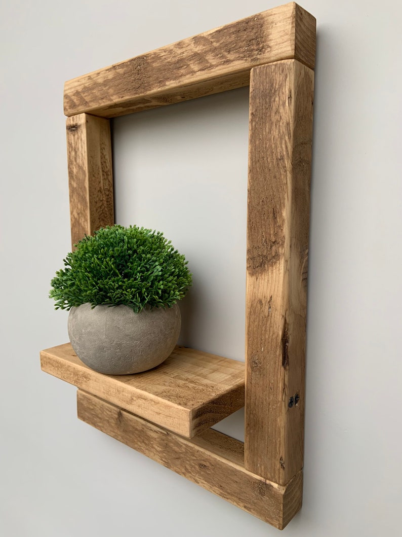 May include: Rustic wooden shelf with a single shelf and a small potted plant. The shelf is made of reclaimed wood and has a natural, weathered finish.