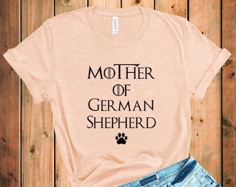 May include: A light beige t-shirt with the text "Mother of German Shepherd" and a paw print.