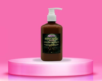 以下が含まれることがあります： 白いポンプディスペンサーが付いた茶色のボトルで、「Ghoully Mocha」とラベル付けされています。ラベルには満月と影のある人物が描かれています。ボトルは、ピンクの背景にピンクの丸みを帯びた台座に展示されています。