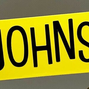 Pu&ograve; includere: Uno striscione giallo con il testo "THE JOHNSONS" in lettere nere.