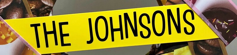 Pu&ograve; includere: Uno striscione giallo con il testo "THE JOHNSONS" in lettere nere.