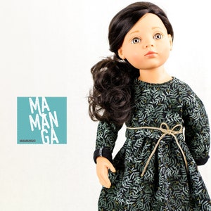 May include: A doll wearing a long-sleeved green dress with a leaf pattern and a brown belt. The doll has long black hair and brown eyes. The doll is wearing a dress with the text "MA MAN GA" and "MAMANGGO" on it.