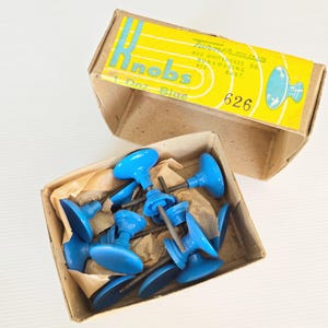 May include: A box of blue plastic knobs with a yellow and white label that reads "Knobs 1 Doz. Blue 626 Turner Mfg. Co. Ltd. 400 Whitehorse Rd. Nunawading Vic. Aust."