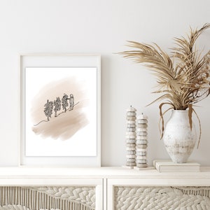 May include: A framed black and white line drawing of three trees with a person walking towards them on a light brown background. The frame is white and the background is a white wall.