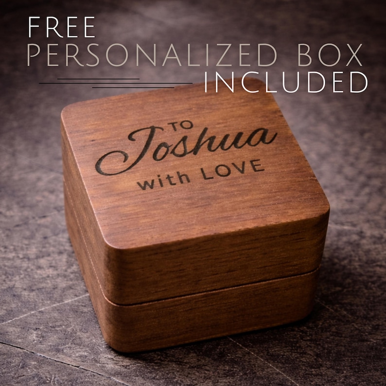 May include: A square wooden box with a hinged lid. The box is a warm brown color and has the words "TO Joshua with LOVE" engraved on the top. The text "FREE PERSONALIZED BOX INCLUDED" is above the box.