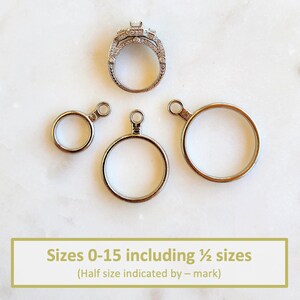 May include: A silver-toned ring sizer set featuring three circular metal rings of varying diameters, each with a small loop at the top. The rings are marked with the numbers 0, 10, and 15. Text at the bottom reads: Sizes 0-15 including &frac12; sizes (Half size indicated by &ndash; mark).