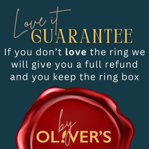 May include: A dark teal graphic featuring the text Love it GUARANTEE. If you don't love the ring we will give you a full refund and you keep the ring box. Below the text is a red wax seal graphic with the gold text by OLIVER'S printed on it.