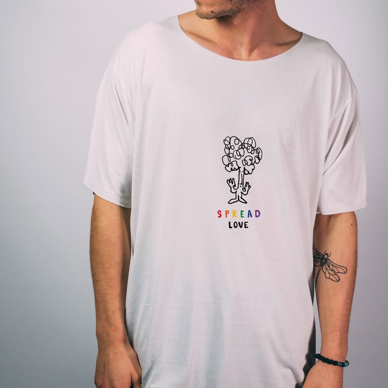 May include: White t-shirt with a black line drawing of a tree with faces for leaves. The text "SPREAD LOVE" is written below the tree in rainbow colors.