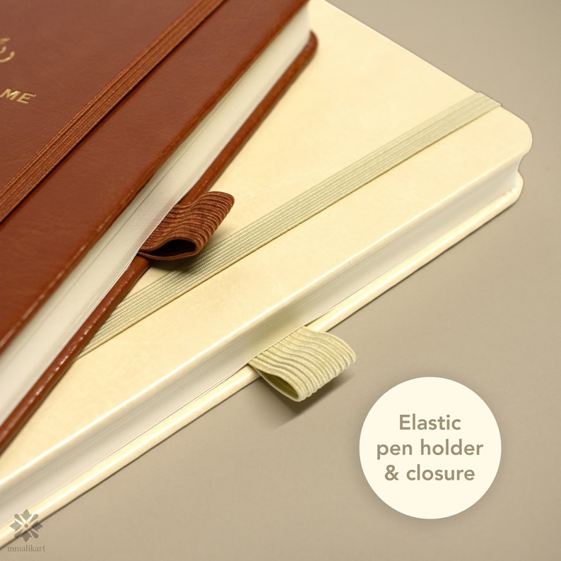 May include: A brown leather-bound journal with a cream-colored interior. The journal has an elastic pen holder and closure.