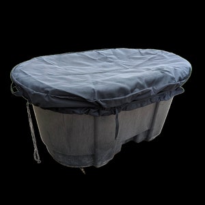May include: A black plastic oval-shaped container with a black fabric cover. The cover has a drawstring closure and is pulled tight around the container.