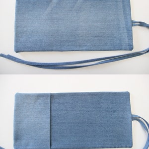 Puede incluir: Una bolsa de mezclilla con cierre de solapa y una correa larga. La bolsa est&aacute; abierta para revelar tres compartimentos rectangulares blancos.