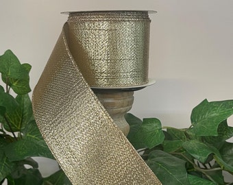 May include: A roll of gold metallic ribbon with a textured finish. The ribbon is wrapped around a wooden spool.