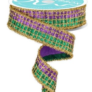 May include: A spool of decorative ribbon with a teal label. The ribbon is a vibrant combination of green, purple, and gold, with a checkered pattern. The edges are trimmed with gold tinsel, adding a touch of sparkle. Perfect for crafting and gift wrapping.