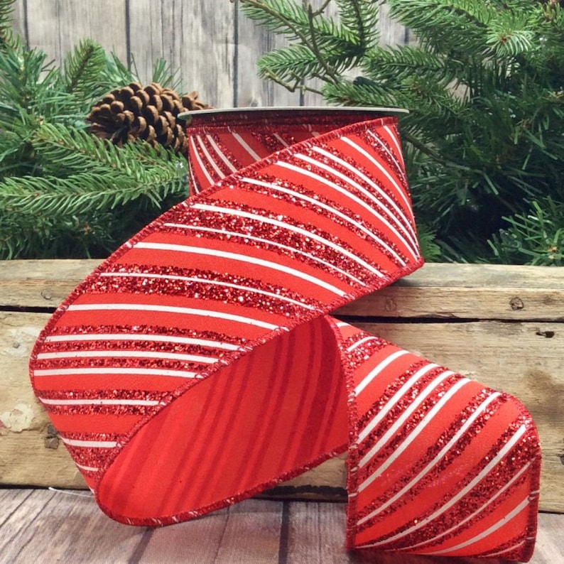May include: Red and white striped ribbon with glitter. The ribbon is made of a soft, textured fabric and has a subtle sheen.