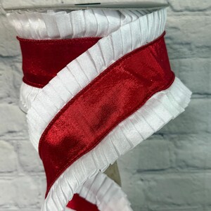 May include: A spool of white pleated ribbon with a vibrant red satin ribbon overlay. The ribbon is tightly wound, showcasing the contrasting textures and colors. Ideal for crafting, gift wrapping, or decorative purposes.