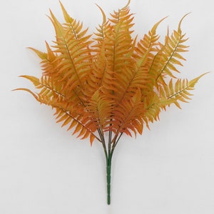 May include: A bunch of artificial orange fern leaves with green stems.