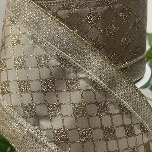 Peut inclure: Rouleau de ruban d&eacute;coratif avec un motif de diamants et de paillettes dor&eacute;es. Le ruban a un fond beige avec un rev&ecirc;tement de paillettes dor&eacute;es et une bordure de paillettes dor&eacute;es. Le ruban est adapt&eacute; &agrave; l'emballage de cadeaux, &agrave; l'artisanat et aux d&eacute;corations de vacances.