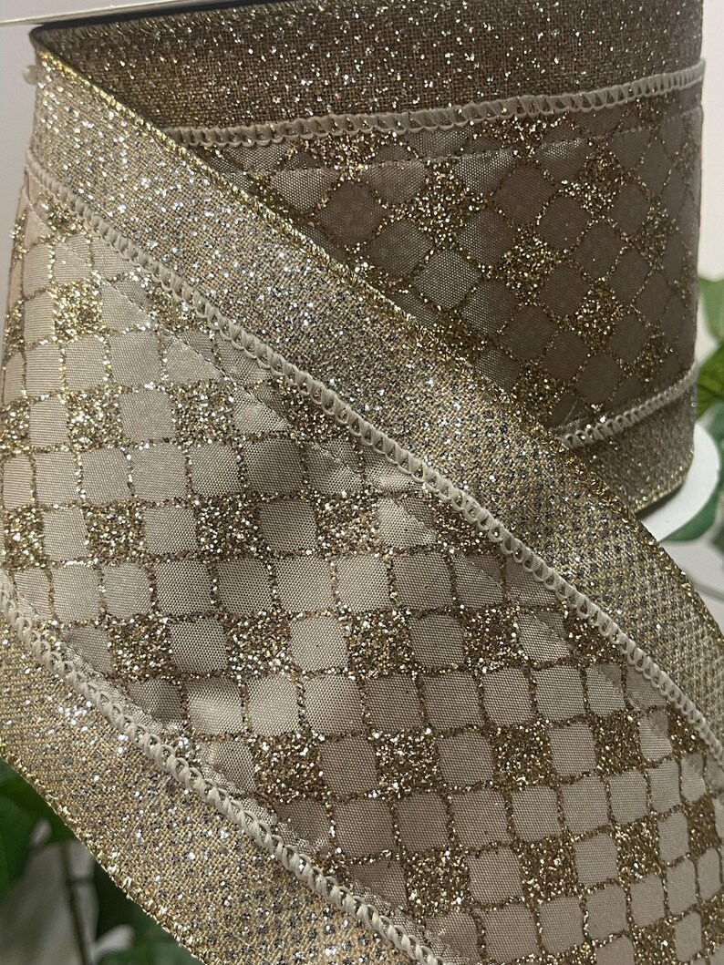 Peut inclure: Rouleau de ruban d&eacute;coratif avec un motif de diamants et de paillettes dor&eacute;es. Le ruban a un fond beige avec un rev&ecirc;tement de paillettes dor&eacute;es et une bordure de paillettes dor&eacute;es. Le ruban est adapt&eacute; &agrave; l'emballage de cadeaux, &agrave; l'artisanat et aux d&eacute;corations de vacances.