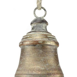 May include: A decorative bell with a distressed, metallic finish. The bell is suspended by a natural rope and has a weathered, antique appearance. The bell's colour is a mix of gold, bronze, and white, with a classic shape.