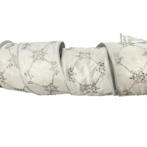 May include: A roll of white ribbon with a silver snowflake pattern. The ribbon is made of a soft, satiny material and is perfect for holiday decorations, gift wrapping, or craft projects. The ribbon is approximately 2.5 inches wide.