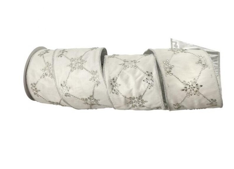 May include: A roll of white ribbon with a silver snowflake pattern. The ribbon is made of a soft, satiny material and is perfect for holiday decorations, gift wrapping, or craft projects. The ribbon is approximately 2.5 inches wide.