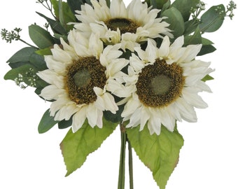Op de afbeelding: Een boeket met drie witte kunstmatige zonnebloemen met groene bladeren en kleine witte bloemen.