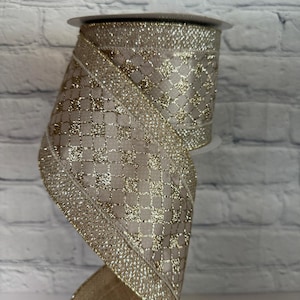Peut inclure: Rouleau de ruban d&eacute;coratif dor&eacute; et beige. Le ruban pr&eacute;sente un motif quadrill&eacute; avec des accents de paillettes dor&eacute;es et une bordure dor&eacute;e. Id&eacute;al pour l'artisanat, l'emballage de cadeaux et les d&eacute;corations de f&ecirc;tes.