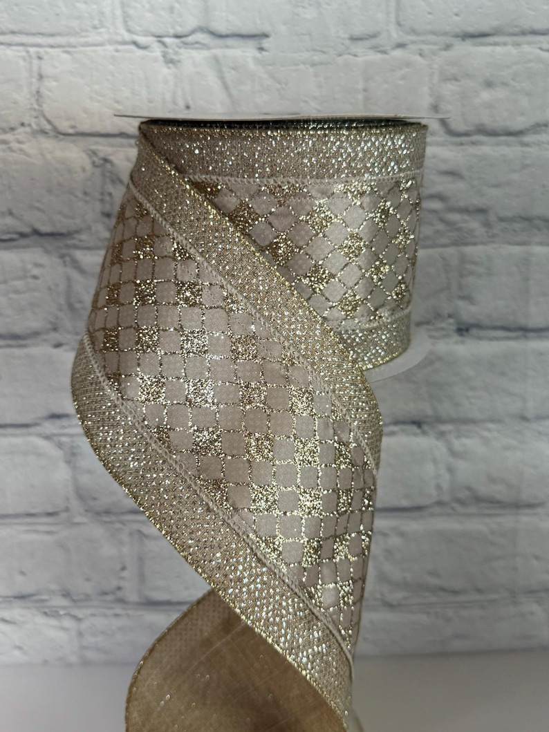 Peut inclure: Rouleau de ruban d&eacute;coratif avec un fond beige et un rev&ecirc;tement dor&eacute; et scintillant. Le ruban pr&eacute;sente un motif de losanges et est bord&eacute; d'une bordure dor&eacute;e scintillante. Id&eacute;al pour l'artisanat, l'emballage de cadeaux et les d&eacute;corations de f&ecirc;tes.