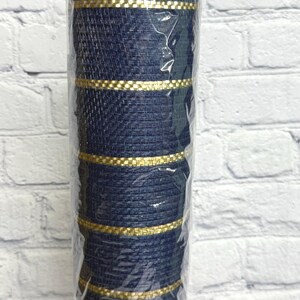 May include: A roll of navy blue woven ribbon with gold metallic stripes. The ribbon is wrapped in clear plastic, and the texture of the weave is visible. The ribbon is likely used for crafting, gift wrapping, or decorative purposes.