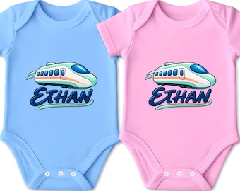 Könnte beinhalten: Zwei kurzärmelige Babybodys, einer in Hellblau und einer in Hellrosa, jeweils mit einer Grafik eines stilisierten weißen und türkisfarbenen Hochgeschwindigkeitszuges über dem Namen Ethan in dunkelblauer Schreibschrift mit türkiser Linie.