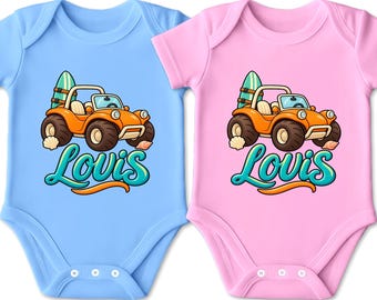 Könnte beinhalten: Zwei kurzärmelige Babybodys, einer in Hellblau und einer in Hellrosa, jeweils mit einer Grafik eines orangefarbenen Dünenbuggys mit Surfbrett am Heck, zwei Muscheln und dem Namen Lovis in großer, türkisfarbener Schreibschrift.