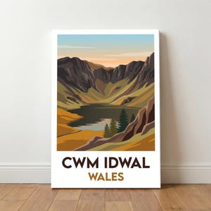 May include: A framed print featuring a landscape of Cwm Idwal, Wales. The image shows a lake nestled between mountains in brown, green, and yellow hues, with an orange and blue sky. The text "CWM IDWAL WALES" is displayed at the bottom.