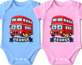 Könnte beinhalten: Zwei kurzärmelige Babybodys, einer in Hellblau und einer in Hellrosa, jeweils mit einer Grafik eines roten Doppeldeckerbusses mit einem gelben Koffer und einem dunkelblauen Banner darunter, auf dem der Name GEORGE in weißen Großbuchstaben steht.