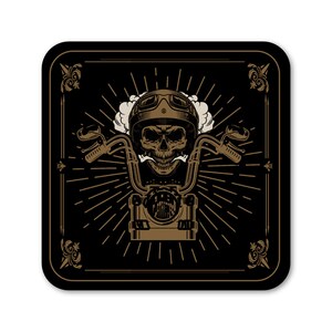 May include: A black and gold illustration of a skull wearing a motorcycle helmet and riding a motorcycle. The skull is surrounded by a sunburst pattern and a decorative frame.