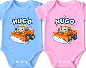 Könnte beinhalten: Ein hellblauer und ein hellrosa Babybody, jeweils mit einer Grafik eines orangefarbenen Schneepflug-LKWs mit lächelndem Gesicht und dem Namen HUGO in großen blauen Buchstaben über dem Fahrzeug, umgeben von kleinen weißen Rauten.